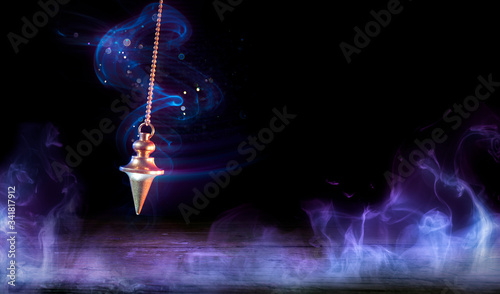 Esoteric And Hypnosis Concept - Pendulum Swinging With Magic Smoke
 photo