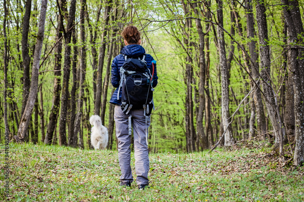 woman trekking alone in green forest
