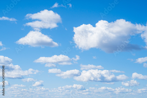 White aerial clouds on a blue sky. Clear good weather. Landscape. Background from the bright blue sky. A lot of clouds in the sky.