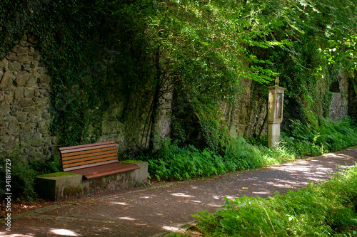 bench near the stone wall in the old park in the monastery