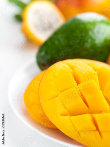 Fresh sweet mango and green avocado on white background. Exotic tropical fruits for healthy and vegeterian diet.