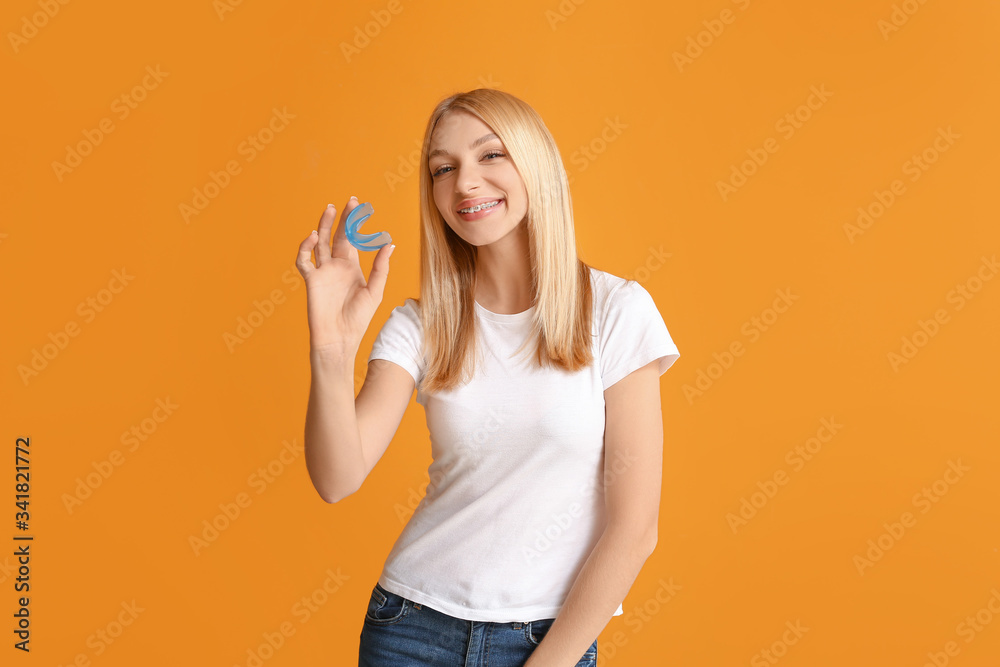 Young woman with dental braces and mouth protector on color background Young woman with dental braces and mouth protector on color background