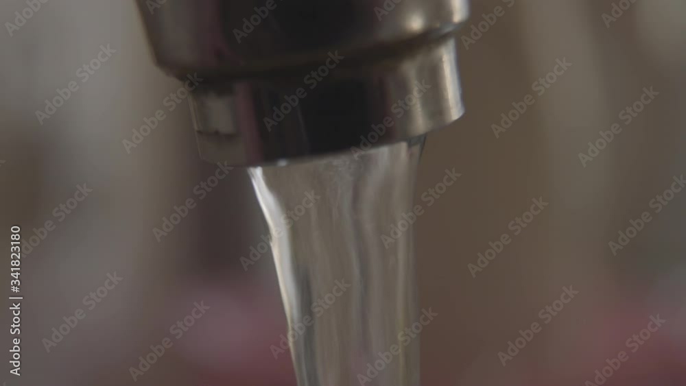Extreme close-up of water running out the faucet. Use of water resources, hygiene, household equipment, plumbing. Extreme close-up of water running out the faucet. Use of water resources, hygiene, household equipment, plumbing.