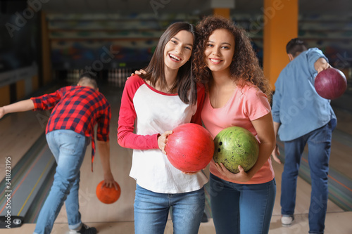 Friends playing bowling in ...
