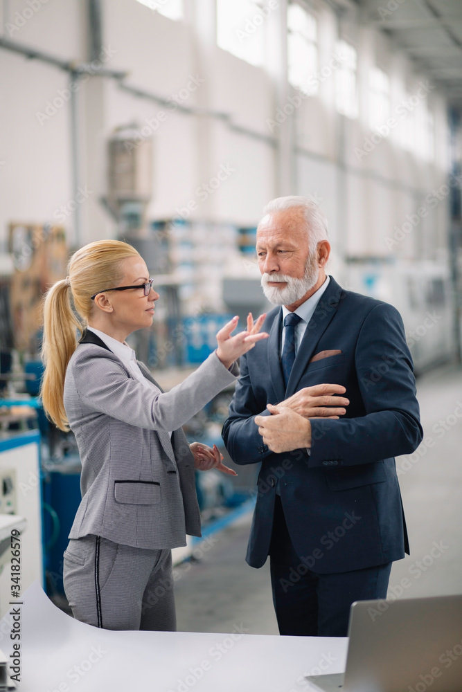 Colleagues working on project. Team of architects discussing business in factory. Colleagues working on project. Team of architects discussing business in factory.