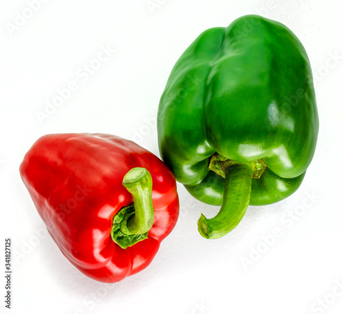 Two fresh peppers one red and one green on a white background 