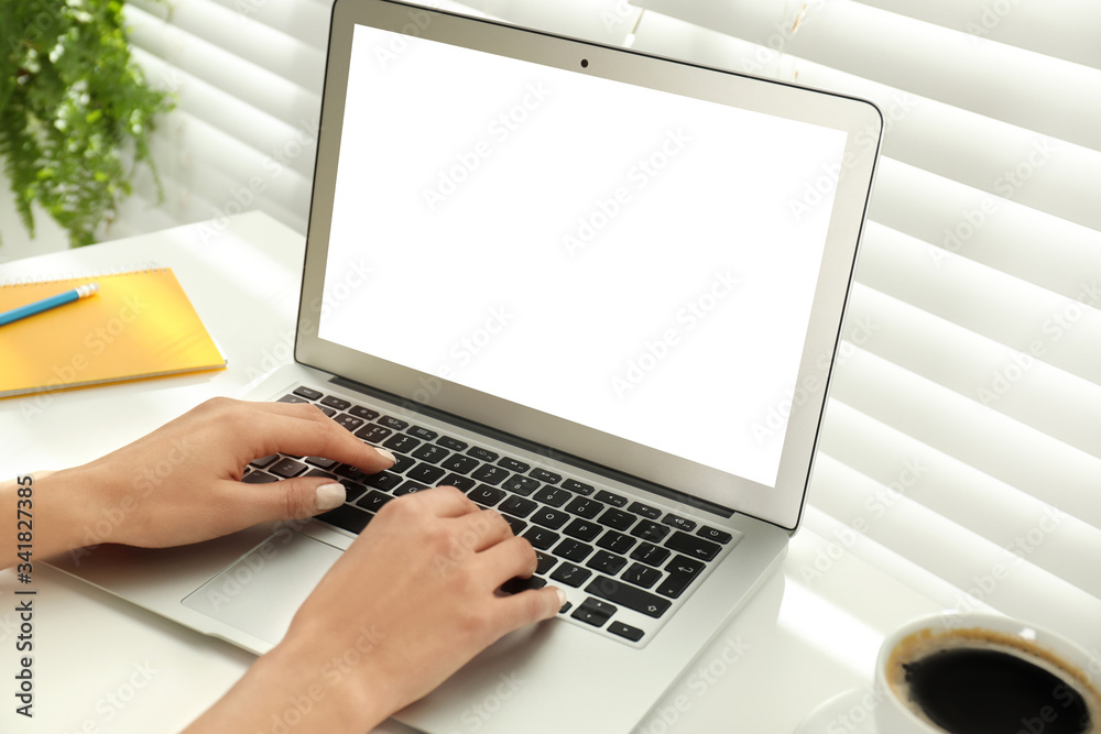 Young woman using modern computer at table in office, closeup. Space for design