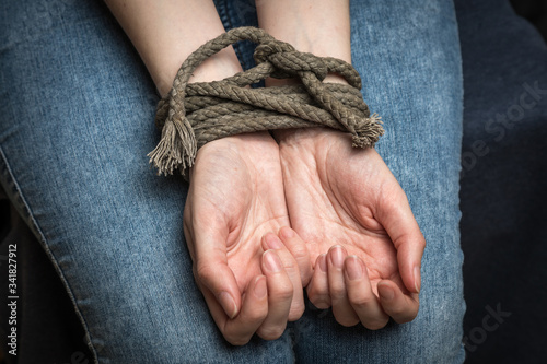 The white woman's hands are tied with an old rope