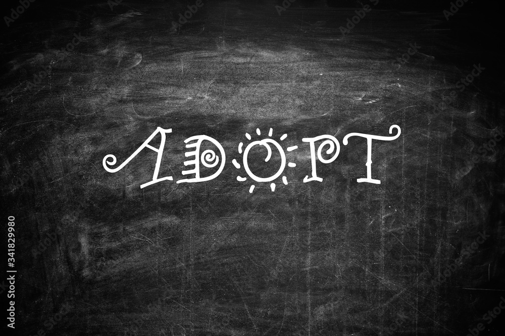 Obraz premium Word ADOPT written with chalk on blackboard, top view. Family concept