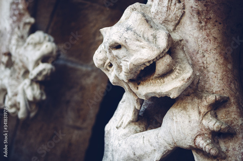 Fierce dragon sculpture guarding and ancient castle portal. Detail of head, mouth and claws