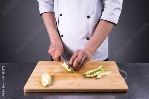 chef cuts and cleans a ripe avocado in the restaurant kitchen9