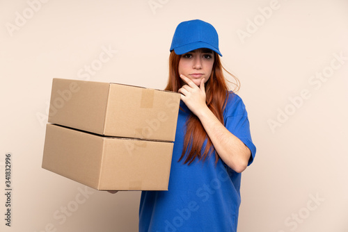 Young teenager delivery girl over isolated background thinking an idea © luismolinero