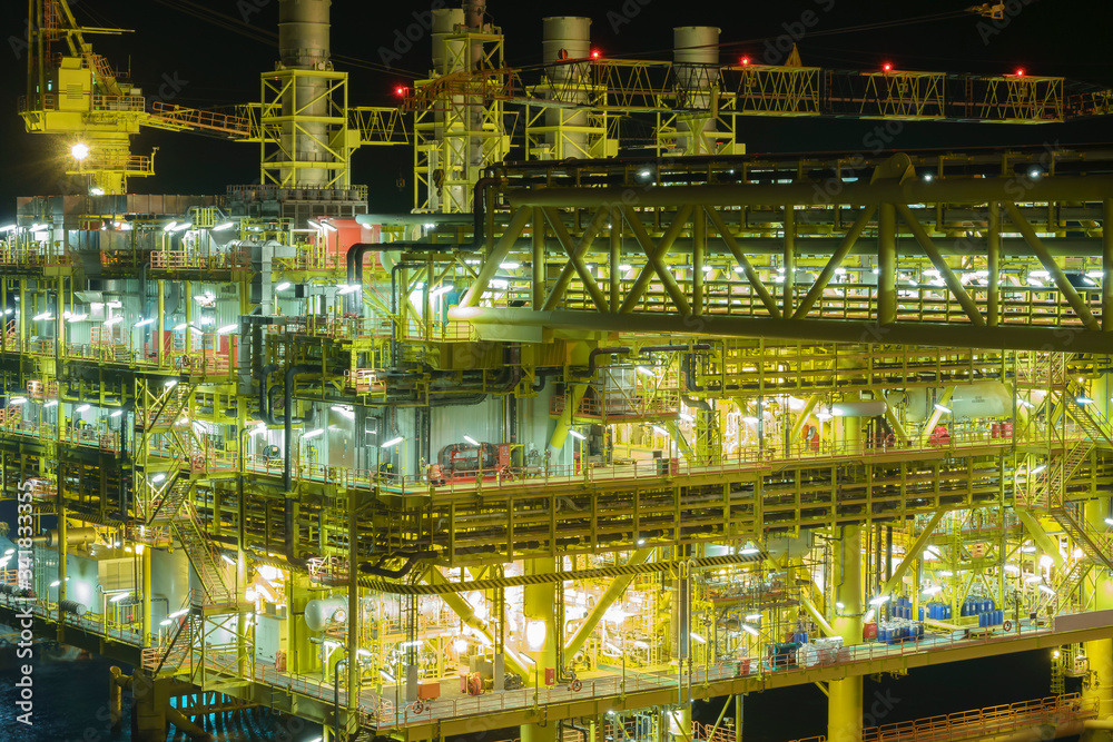 Oil and gas industry. Night scene at oil and gas platform complex at process area with pipelines and valves.      