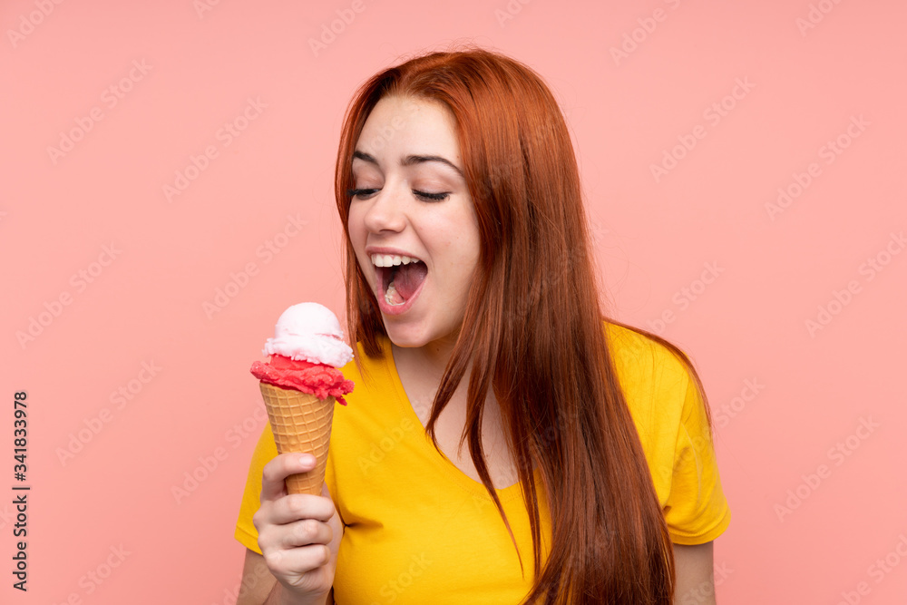 Redhead teenager girl with a cornet ice cream over isolated background Redhead teenager girl with a cornet ice cream over isolated background
