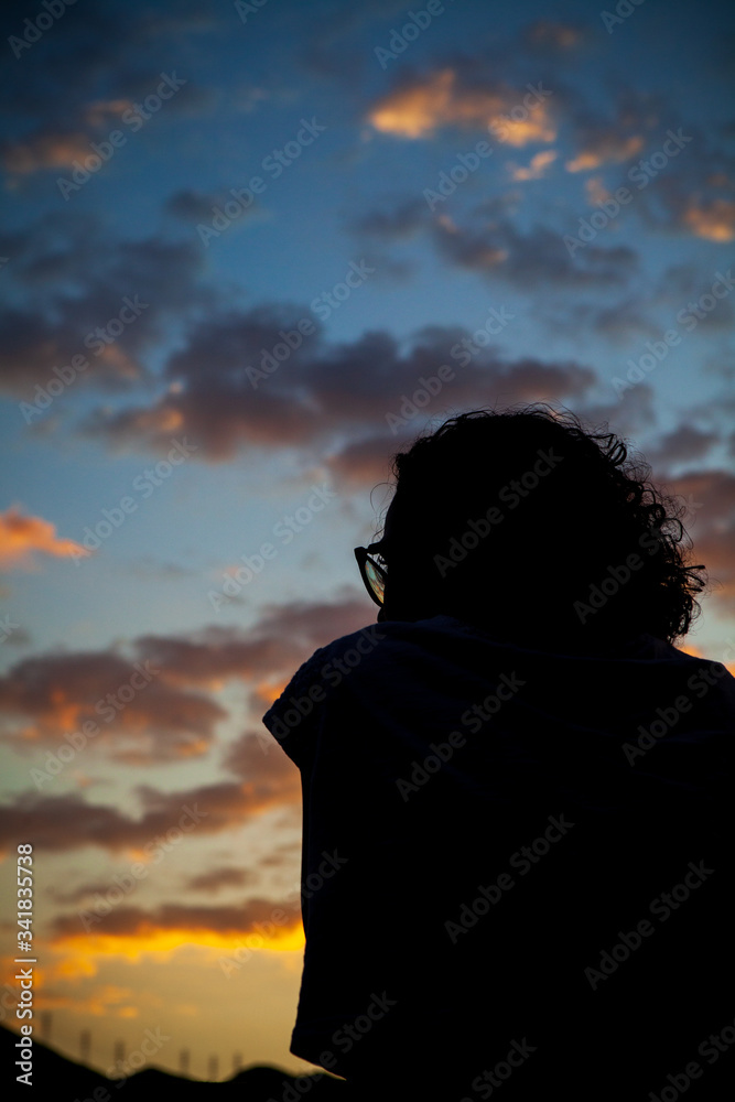 A woman in silhouette watches the sky of a beautiful sunset in the city of Rio de Janeiro. A woman in silhouette watches the sky of a beautiful sunset in the city of Rio de Janeiro.