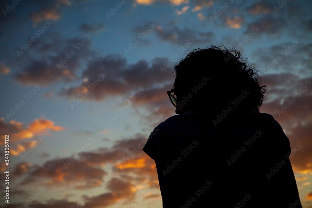 Fototapeta premium A woman in silhouette watches the sky of a beautiful sunset in the city of Rio de Janeiro.