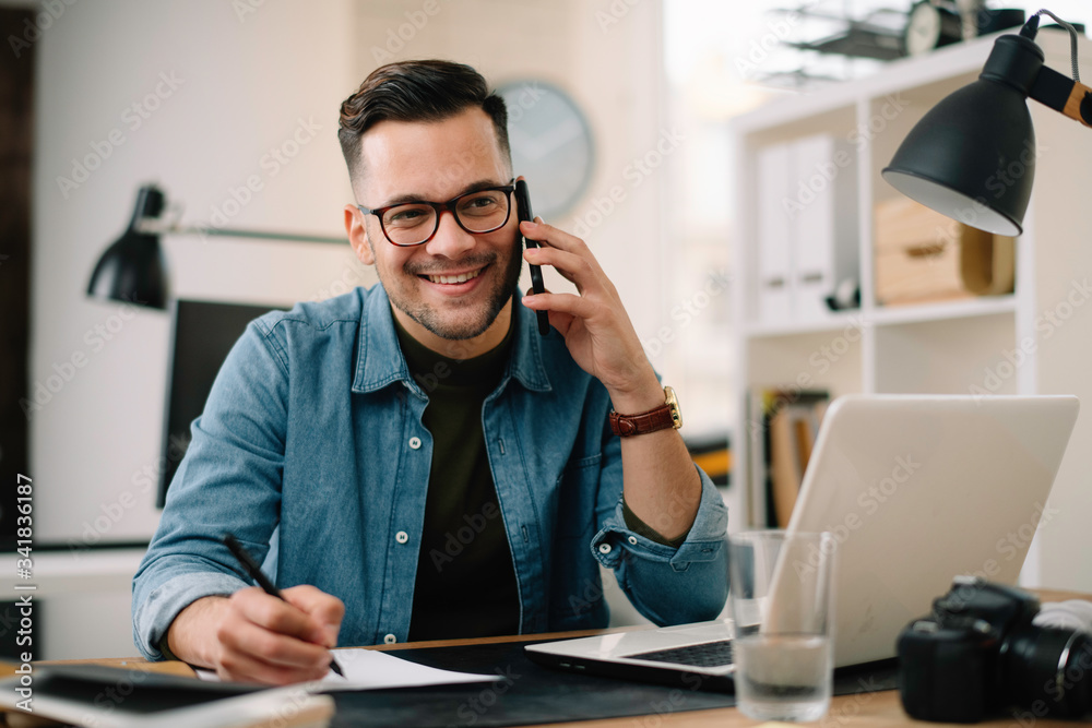 Businessman in office. Handsome man talking on phone at work Businessman in office. Handsome man talking on phone at work