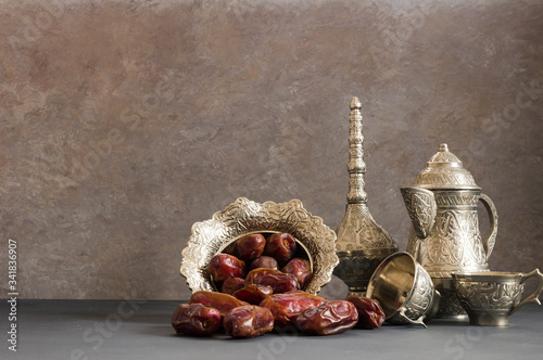 Ramadan kareem with dried dates and authentic metal zamzam water carafe, blessed mounth concept, copy space selective focus