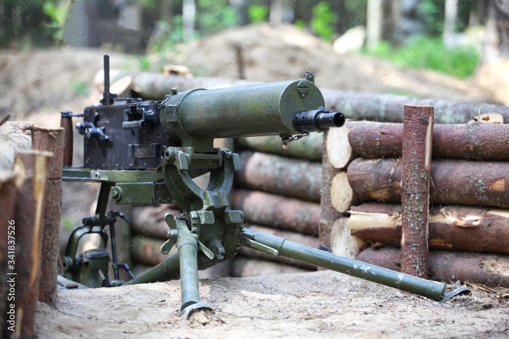 World war II machine gun in a wooden trench in the forest