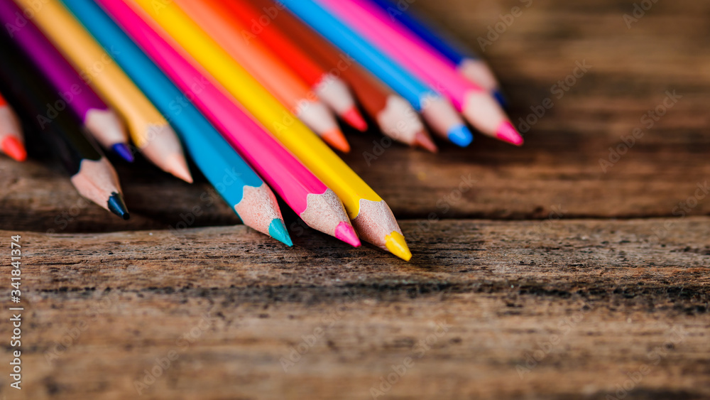 Colored pencils arranged on brown, old rustic wood. The concept of education for children. Back to school or study from home Colored pencils arranged on brown, old rustic wood. The concept of education for children. Back to school or study from home