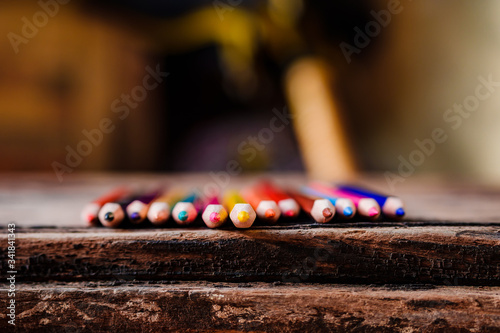 Colored pencils arranged on brown  old rustic wood. The concept of education for children. Back to school or study from home