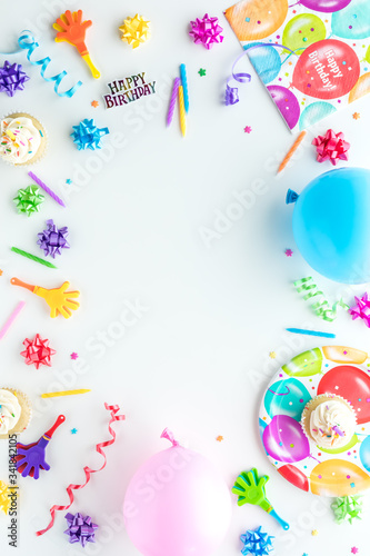 A top down view of birthday party items arranged in a border frame.