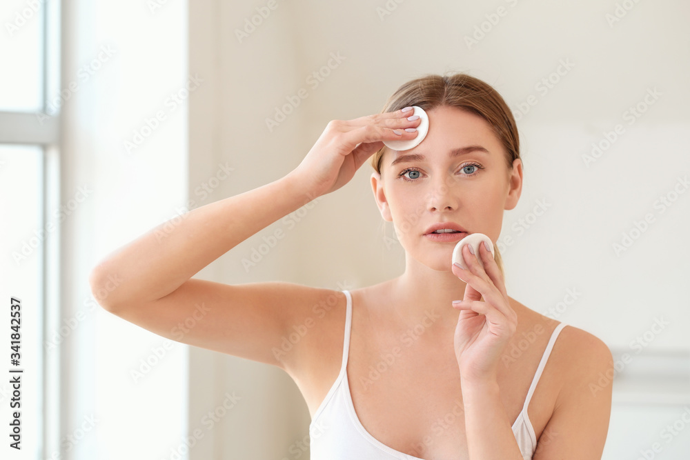 Beautiful young woman removing makeup at home Beautiful young woman removing makeup at home