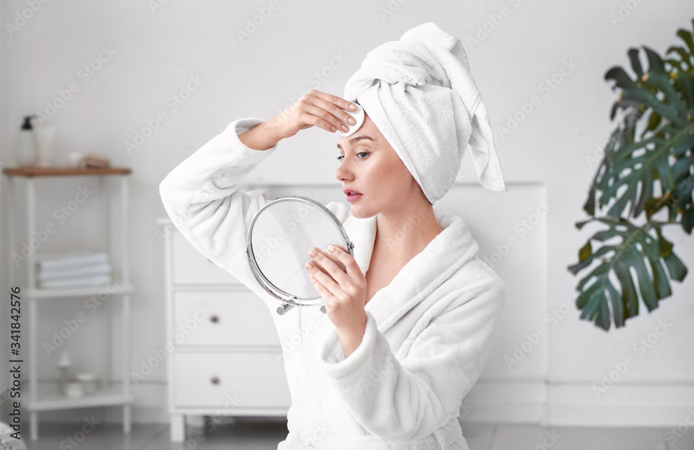 Beautiful young woman removing makeup at home Beautiful young woman removing makeup at home