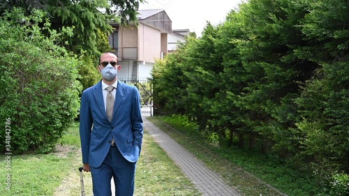 Young businessman taking off his protection mask on alleyway. End of quarantine