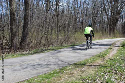 Man in lime green shirt riding on the North Branch Trail at Blue Star Memorial Woods in Glenview, Illinois