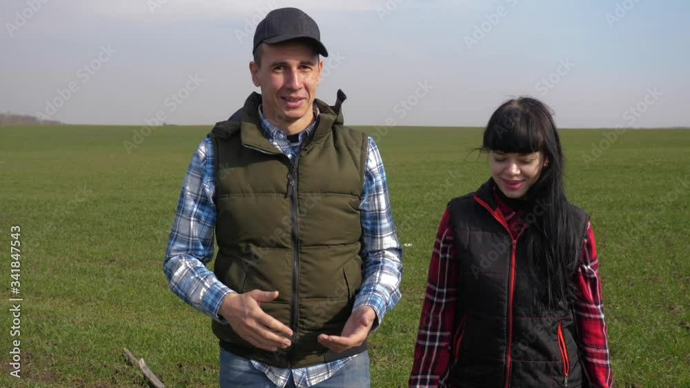 happy family of farmers teamwork a red neck works go on the green field. lifestyle man and girl farmer are studying eco farming farming harvesting concept. woman and worker go walking on agricultural happy family of farmers teamwork a red neck works go on the green field. lifestyle man and girl farmer are studying eco farming farming harvesting concept. woman and worker go walking on agricultural