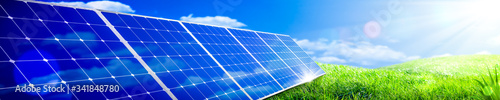 Banner Of Solar Panels In Green Grass Landscape With Blue Sky And Sunlight - Clean Energy Concept photo