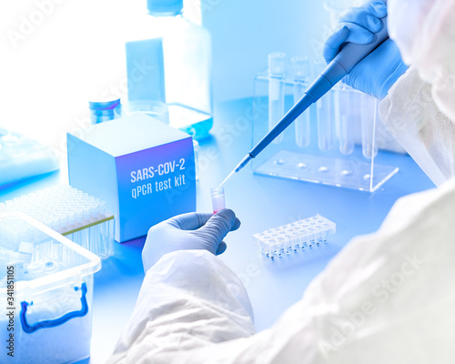 Epidemiologist in protective suit, mask and glasses works with patient swabs to detect specific region of 2019-nCoV virus causing Covid-19 viral pneumonia. Pcr diagnostics kit concept for SARS-CoV-2.. photo