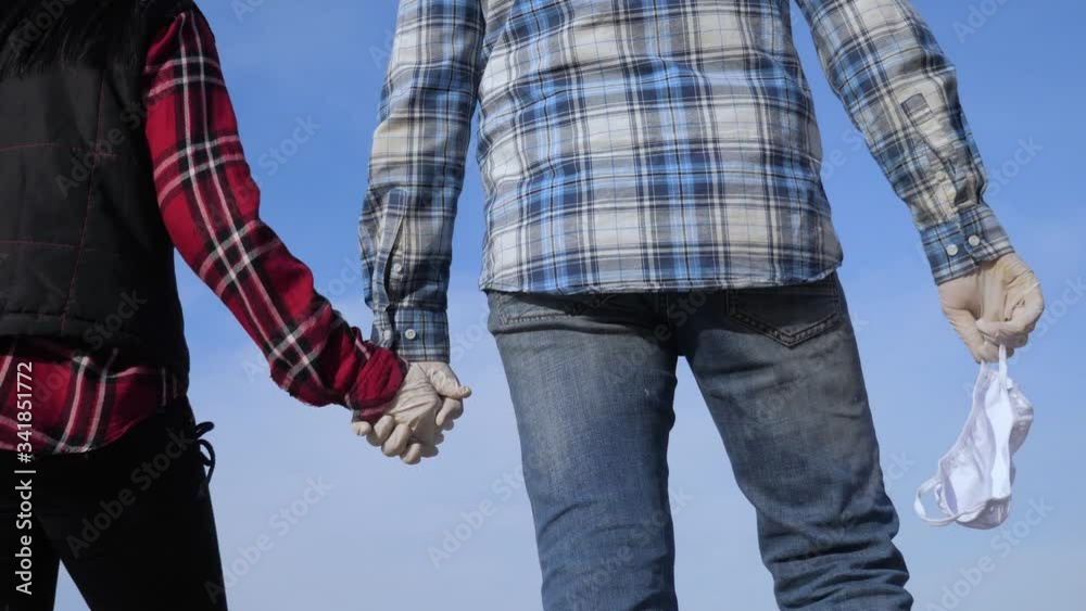 volunteers a holding hands teamwork. concept pandemic virus epidemic world catastrophe infection covid. man and woman couple in gloves hold hands. holding medical mask lifestyle pandemic concept volunteers a holding hands teamwork. concept pandemic virus epidemic world catastrophe infection covid. man and woman couple in gloves hold hands. holding medical mask lifestyle pandemic concept