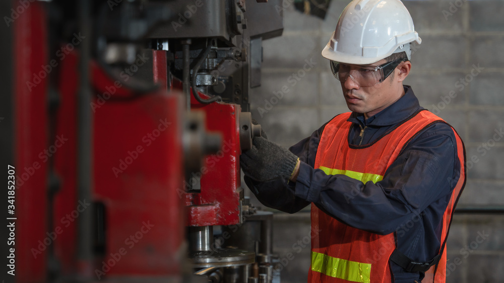 asian male machanic engineer supervisor checking and tuning drilling machine in metwork and part manufacturing factory asian male machanic engineer supervisor checking and tuning drilling machine in metwork and part manufacturing factory