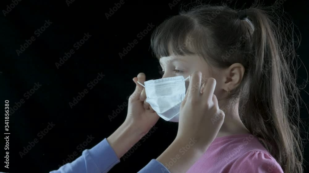 Protection outbreak. A mother puts on a protective mask for her little daughter. Protect yourself from the coronavirus. Protection outbreak. A mother puts on a protective mask for her little daughter. Protect yourself from the coronavirus.