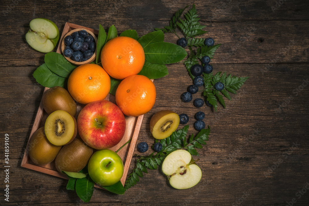 Fresh high vitamin c fruits, different fruits on old wooden table,The fresh apple, orange, blueberry, kiwi, Different raw fruits background.Healthy eating. Fresh high vitamin c fruits, different fruits on old wooden table,The fresh apple, orange, blueberry, kiwi, Different raw fruits background.Healthy eating.