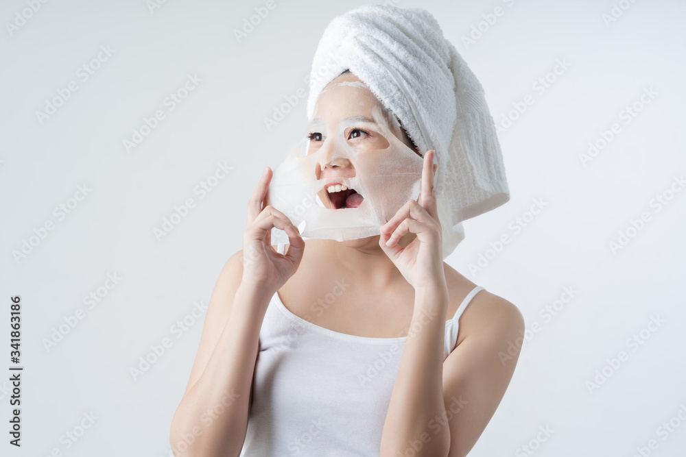 Asian woman is facial mask sheet . She is happy and surprise. Asian woman is facial mask sheet . She is happy and surprise.