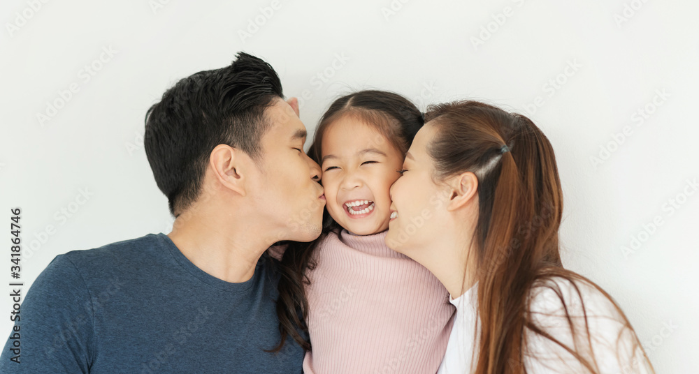 Happy Asian family. Young Father and Mother kiss in their daughter cheek together. Happy Asian family. Young Father and Mother kiss in their daughter cheek together.