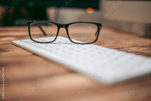 Glasses for sight and vision correction and protection from computer on the wooden table on the keyboard