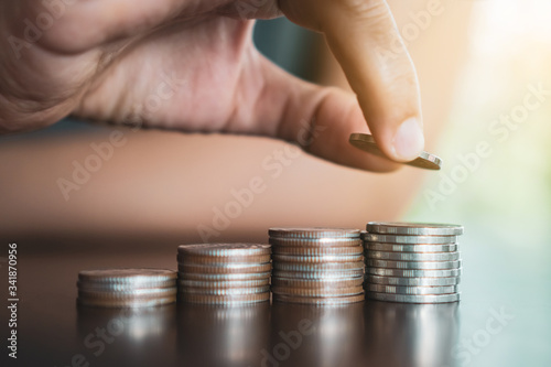 Gold coins on table and green nature bokeh background.