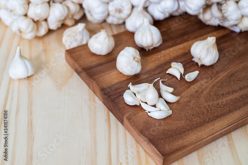 Closeup of garlic cloves on a wooden cutting Board with garlics blur background.