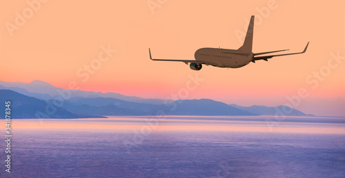 Airplane flying above tropical sea at amazing sunset © muratart