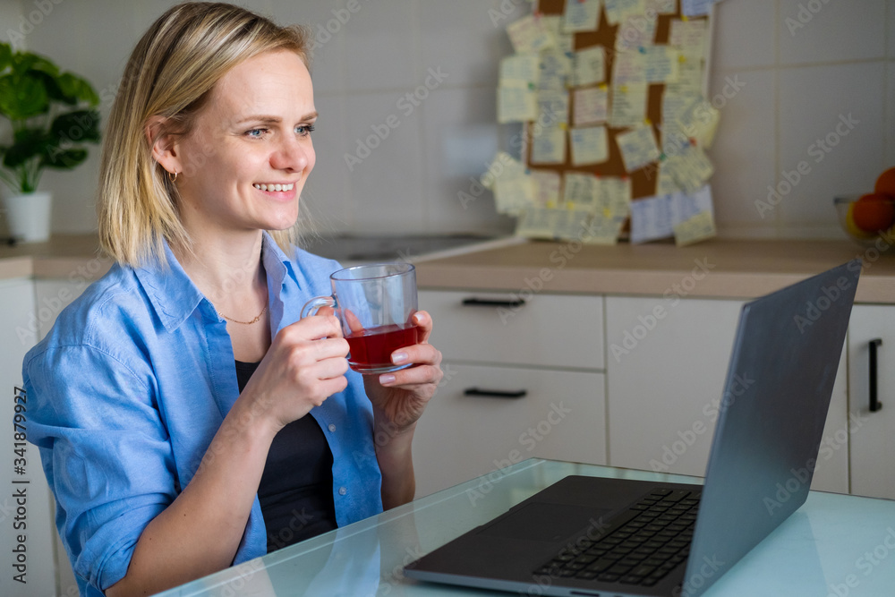 Happy woman using laptop pc for video call friends and parents, smiling girl sitting at home kitchen fun greeting online by computer webcam making videocall. Happy woman using laptop pc for video call friends and parents, smiling girl sitting at home kitchen fun greeting online by computer webcam making videocall.