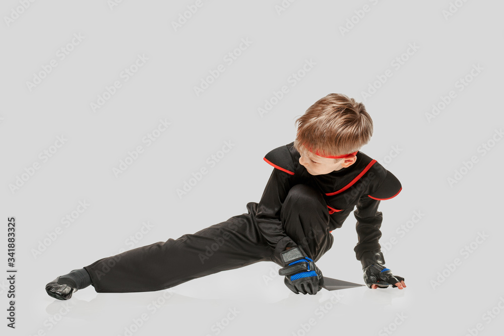 Young ninja boy practicing self-defense technigue with throwing knife Young ninja boy practicing self-defense technigue with throwing knife