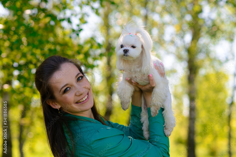 Young girl with her dog. Puppy white dog is running with it's owner. Concept about friendship, animal and freedom. Young girl with her dog. Puppy white dog is running with it's owner. Concept about friendship, animal and freedom.