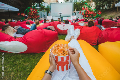 laying eating snacks watching movie at open air cinema