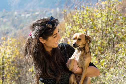 Happy Young Woman Hugging her Adopted Dog in the Mountain 