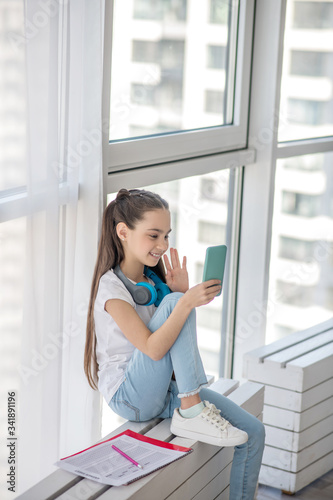 Pretty girl in jeans having a video call Free Download Pretty girl in jeans having a video call - GFXLoad