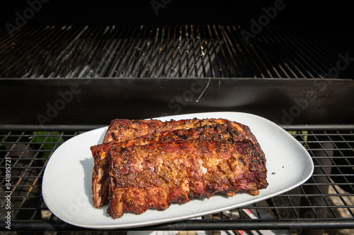 Grilled spareribs lying on a white plate